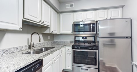 A kitchen with white cabinets and stainless steel appliances.