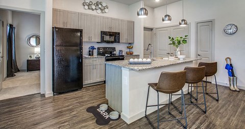 a kitchen with a bar and stools and a refrigerator