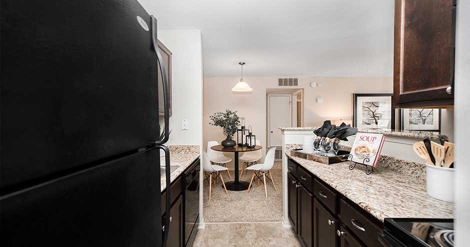 a kitchen with a black refrigerator freezer next to a table