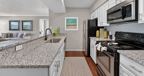 A kitchen with granite countertops and stainless steel appliances.