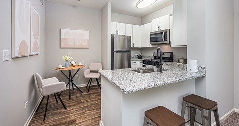 A kitchen with a table and chairs.