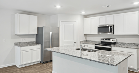 A kitchen with white cabinets and granite countertops.