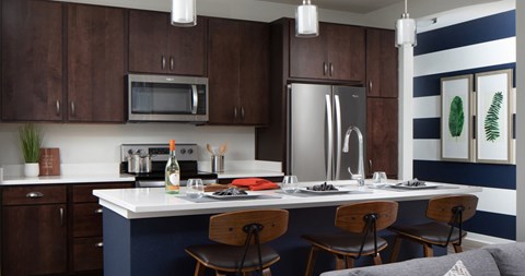 A kitchen with dark brown cabinets and a white countertop.