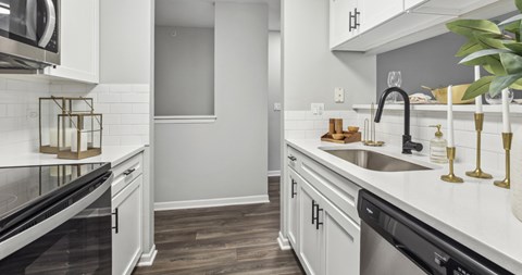 A modern kitchen with white cabinets and a black oven.