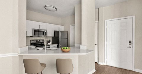 a kitchen with white cabinets and a island with two chairs