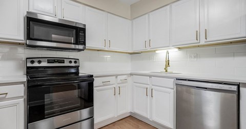 A kitchen with white cabinets and stainless steel appliances.