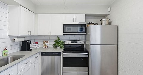 A kitchen with white cabinets and stainless steel appliances.