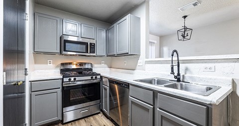 a kitchen with stainless steel appliances and white counter tops