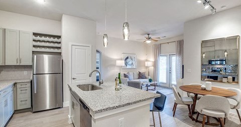a kitchen and living room with a table and a refrigerator