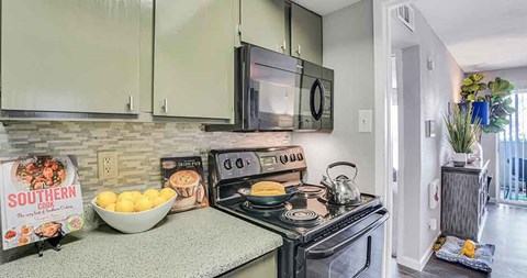 A kitchen with a stove top oven and microwave above it.