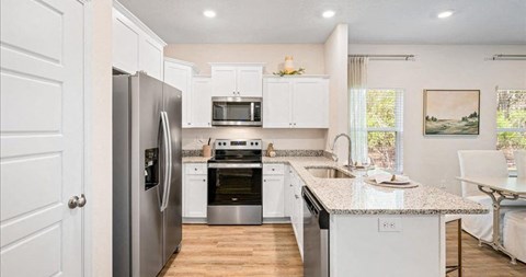 a kitchen with stainless steel appliances and white cabinets