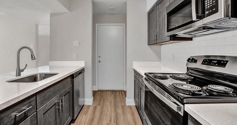 a kitchen with black cabinets and white countertops