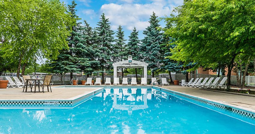 a swimming pool with chairs and a gazebo