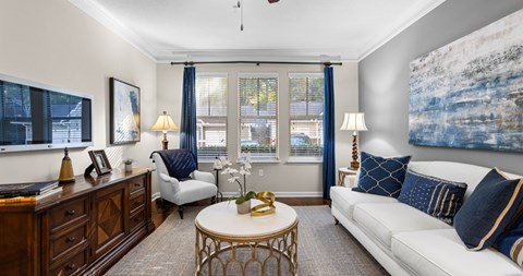 A living room with a white couch, a coffee table, and a painting on the wall.