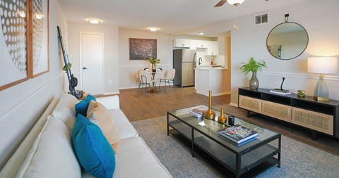 A living room with a white couch and a glass coffee table.