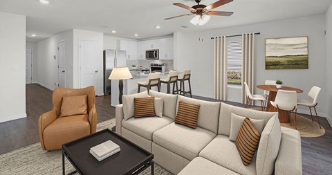 A living room with a beige sofa, a brown armchair, and a coffee table with a book on it.