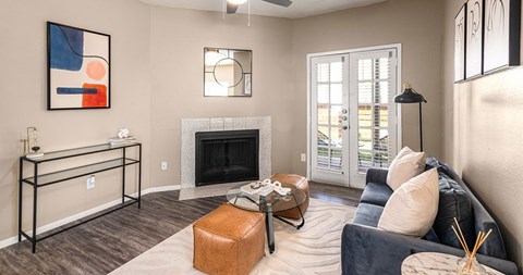 A living room with a fireplace, a couch, and a painting on the wall.