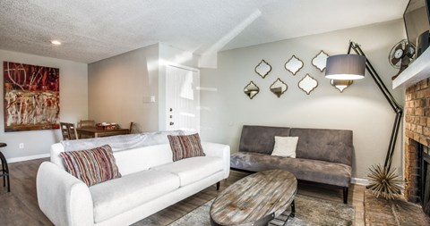 A living room with a white couch and a fireplace.