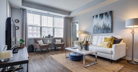 A living room with a white couch, a coffee table, and a painting on the wall.