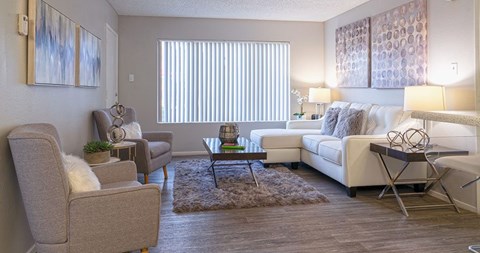 A living room with a white couch, a grey armchair, and a coffee table.