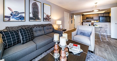 A living room with a grey couch and a coffee table with candles on it.