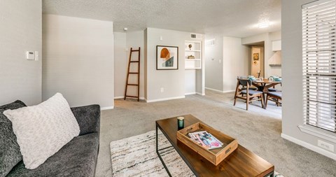 A living room with a grey couch and a wooden coffee table.