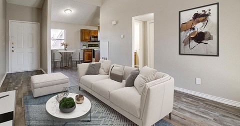 A living room with a white couch and a painting on the wall.
