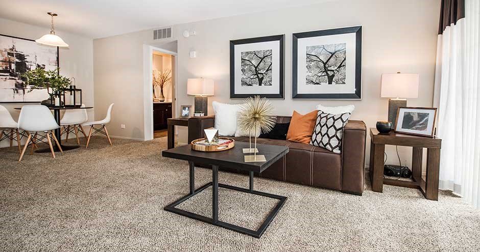 a living room with a couch table and chairs