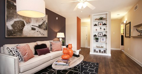 A living room with a white couch and a black and white rug.