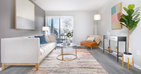 A living room with a white sofa, a coffee table, and a large painting on the wall.