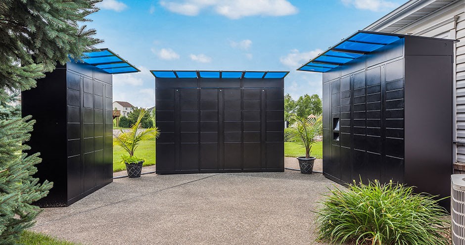 a courtyard with three black gates with a blue sky in the background