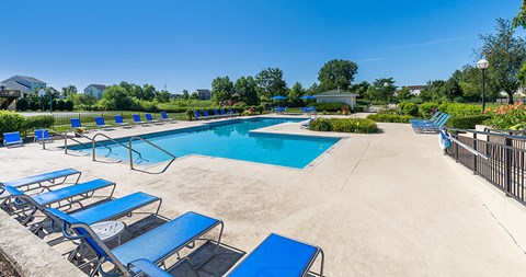 a swimming pool with blue chairs and chairs around it