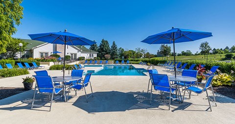 a pool with blue chairs and umbrellas