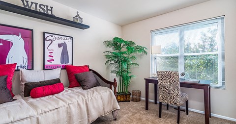a bedroom with a bed and a desk and a window