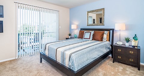 a bedroom with a bed and a sliding glass door