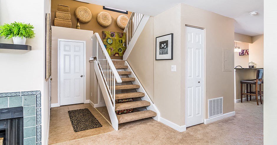 a living room with a staircase and a fireplace