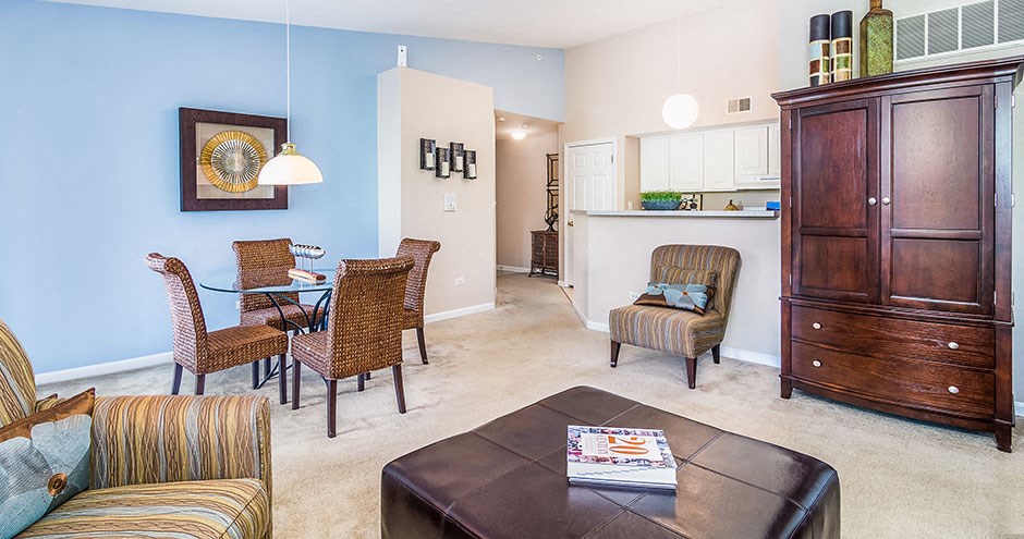 a living room and dining room with a table and chairs