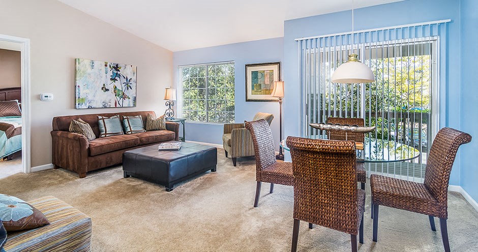 a living room and dining room with a table and chairs