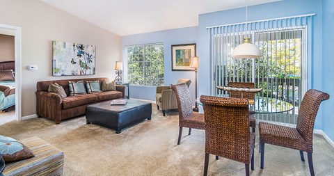 a living room and dining room with a table and chairs