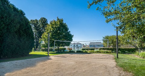 a volleyball court in a park with a house in the background