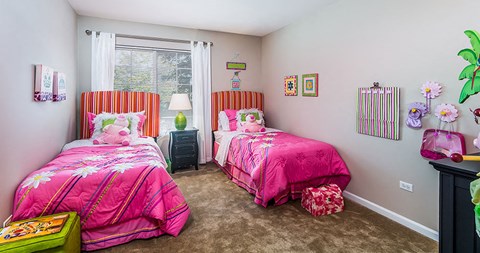 a bedroom with two beds and a window