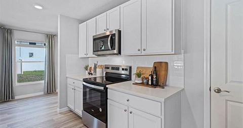 A kitchen with white cabinets and a black oven.