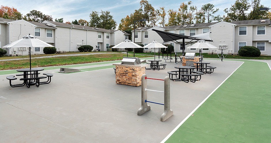 our apartments have an outdoor tennis court with tables and umbrellas