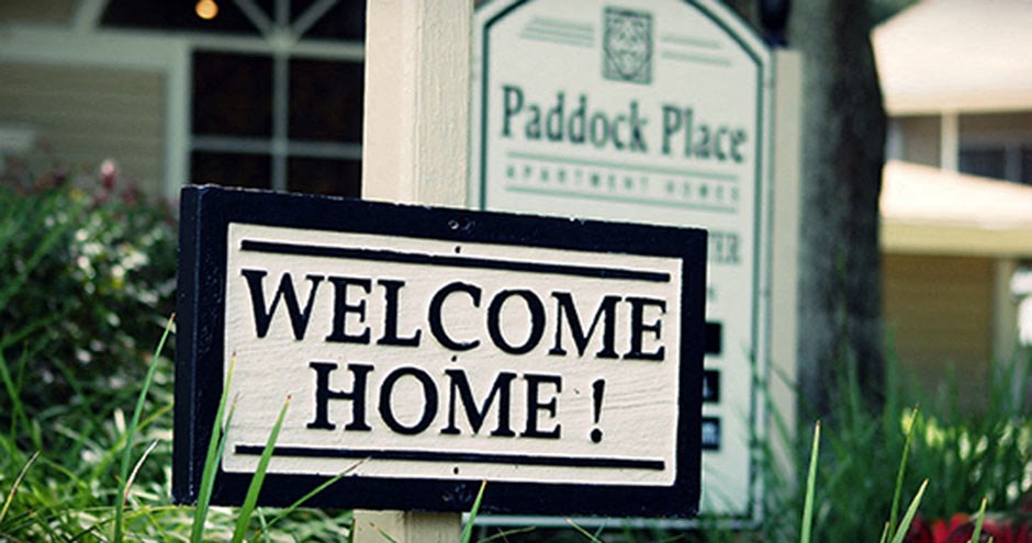 a sign that reads welcome home in front of a mailbox
