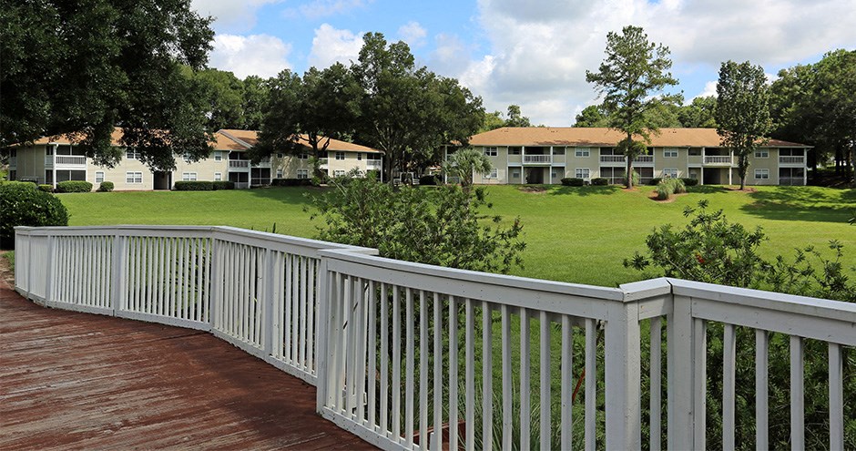 a view of the lawn of an apartment building from a deck