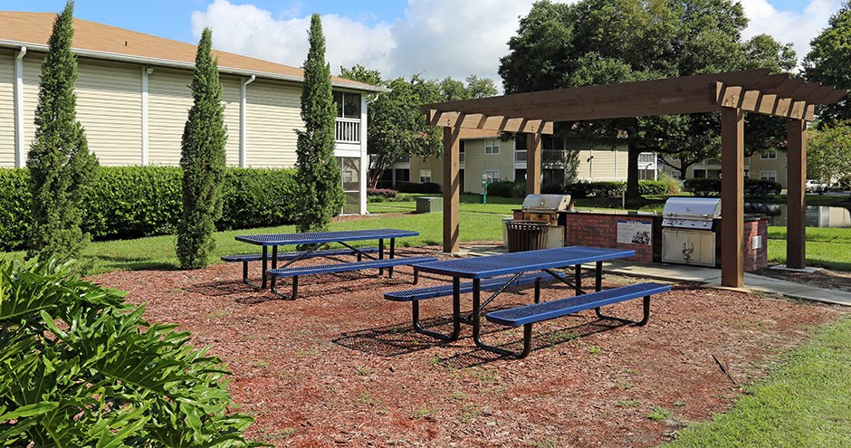 a picnic area with picnic tables and a pergola