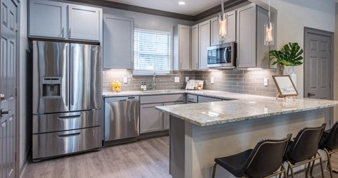 a kitchen with stainless steel appliances and a marble counter top