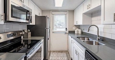 A kitchen with a black stove top oven and a black microwave.