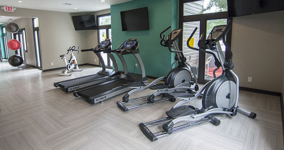 a row of exercise bikes in a gym with a tv