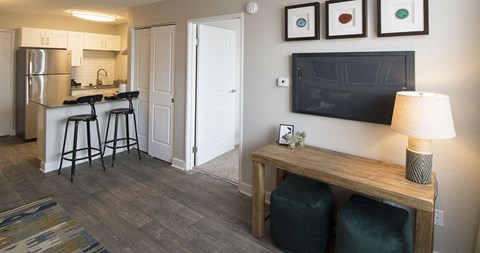 a living room with a tv and a kitchen with a bar